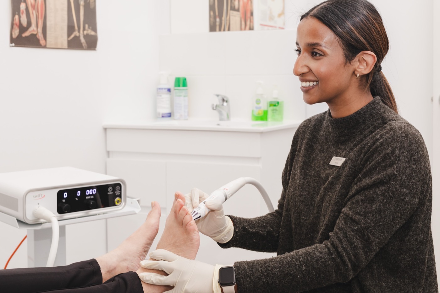 A Medical Foot Care podiatrist treating a patient with SWIFT therapy